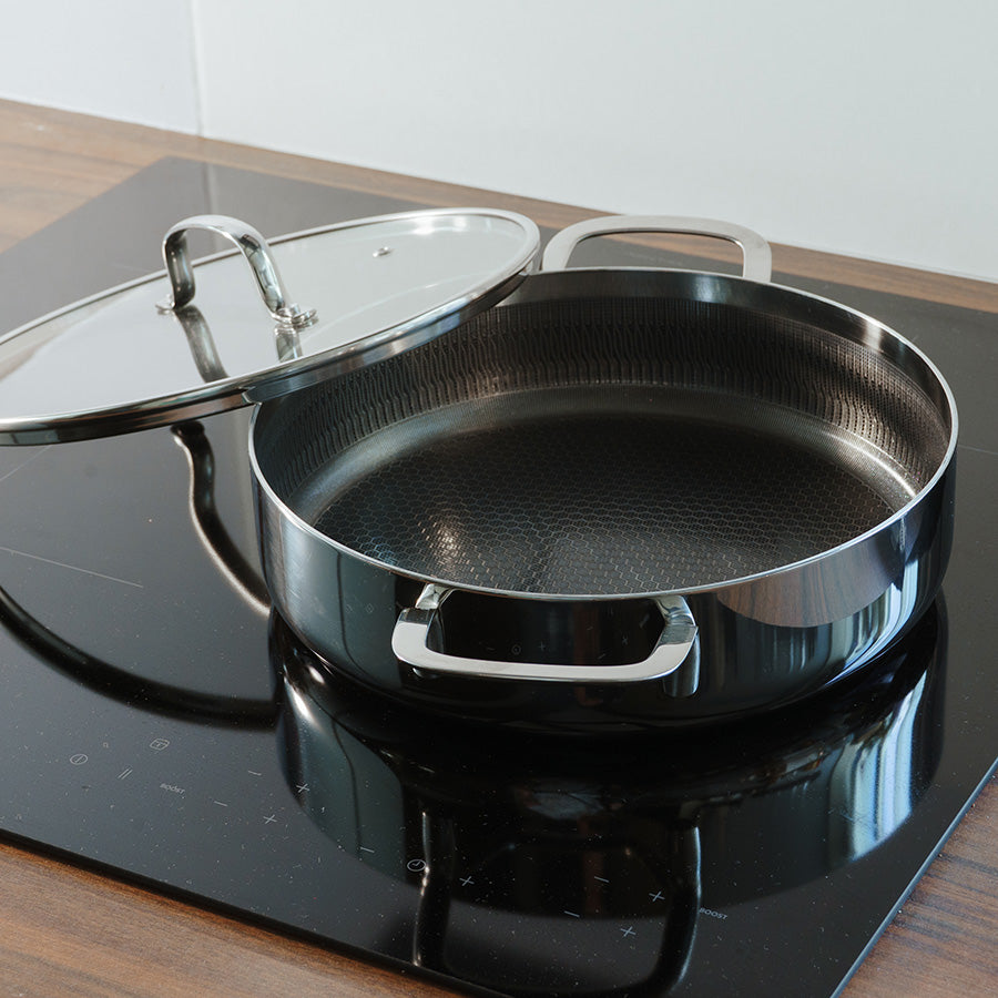 Ask sautepanne med høye kanter og glasslokk på moderne induksjonstopp