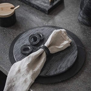 Gråbordskåner i marmor, dekorert med servietter og marmorholdere, som gir en stilfull borddekkning.