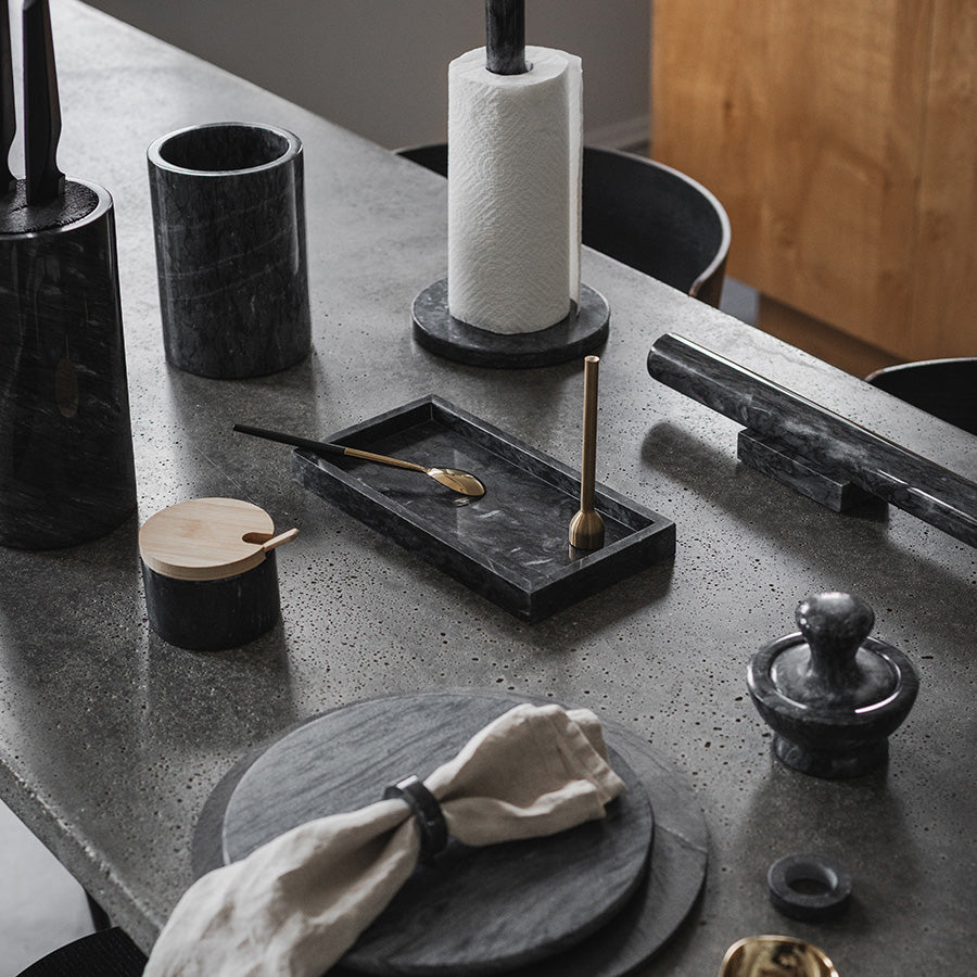 Brett i grå marmor omgitt av kjøkkenutstyr, fremhever stil og funksjonalitet.
