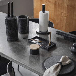 Flott sett med marmor knivblokk og tilbehør på et moderne kjøkkenbord.