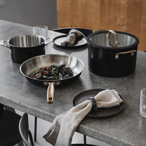 Middagsbord med grytesett fra Ask Obsidian, inklusive gryte og stekepanne, i bruk med skalldyr.