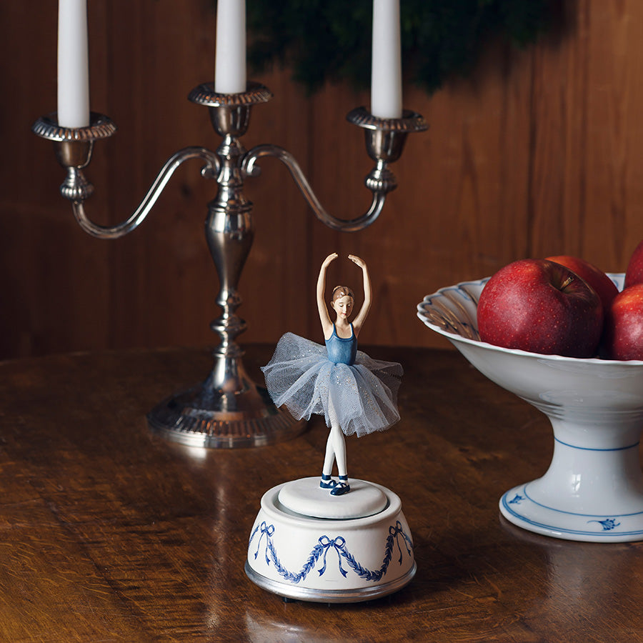 Porsgrunds Porselænsfabrik PP Jul Ballerina Spilledåse 20,5cm plassert på et bord med lysestake og epler, fremhever den nostalgi og eleganse.