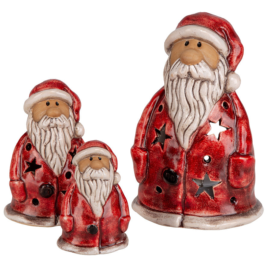 Rød keramisk nisse med stjerneutskjæringer vist sammen med mindre nisser i samme serie