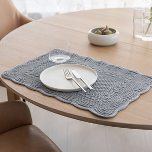 Stilig dekkebrikke laget av quiltet velour, presentert med et hvitt tallerken og bestikk, som gir et pent bordoppsett.