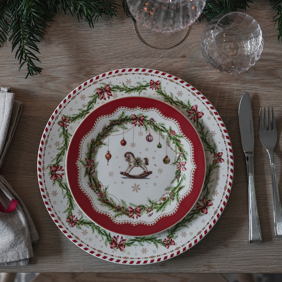 Juleglede tallerken med kjepphestmotiv, røde detaljer og juledekket bord med bestikk
