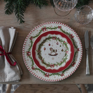 Juleglede tallerken med kjepphest, julekuler og granbar sett ovenfra på julebord