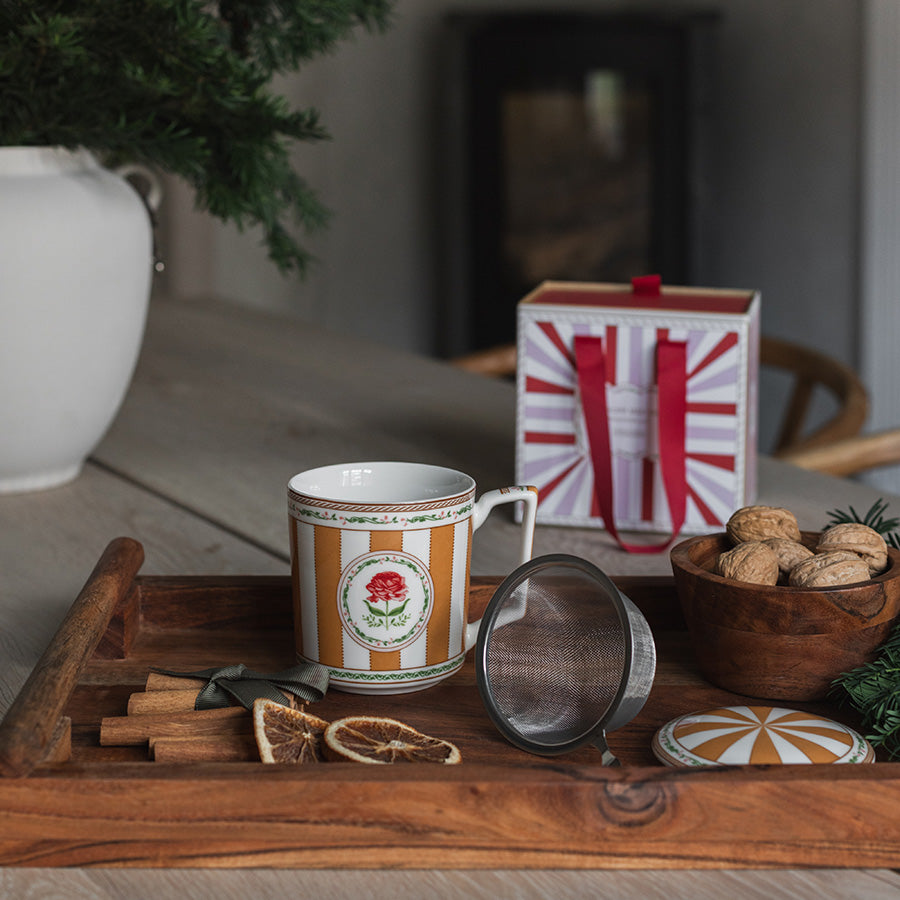 Karamellfarget tekopp med tesil og lokk i julepyntet setting på trebord