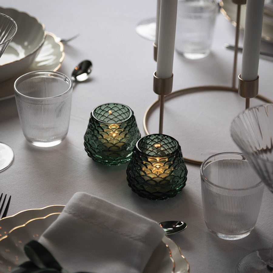 To grønne Furu telysholdere med levende lys på elegant dekket julebord