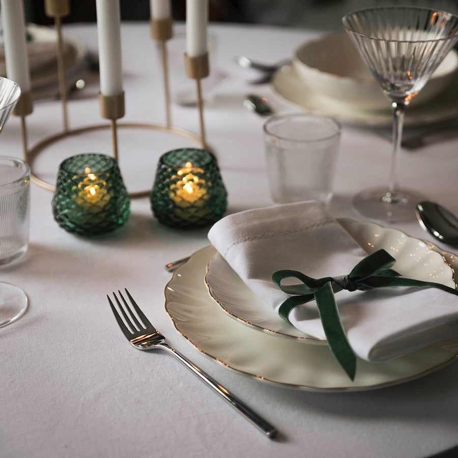 Grønne telysholdere med levende lys som skaper varm stemning på julebordet