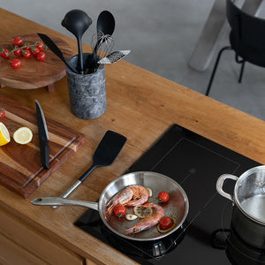 En stekepanne med reker og tomater, med Classicpro ballongvisp og andre kjøkkenredskaper synlige.