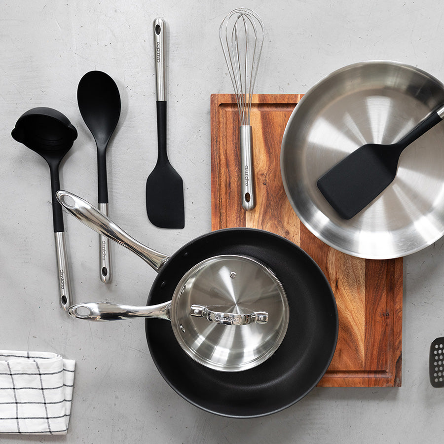 Kjøkkenredskaper fra Classicpro, inkludert øse, stekespade og visp, på en tre-plate med moderne design.