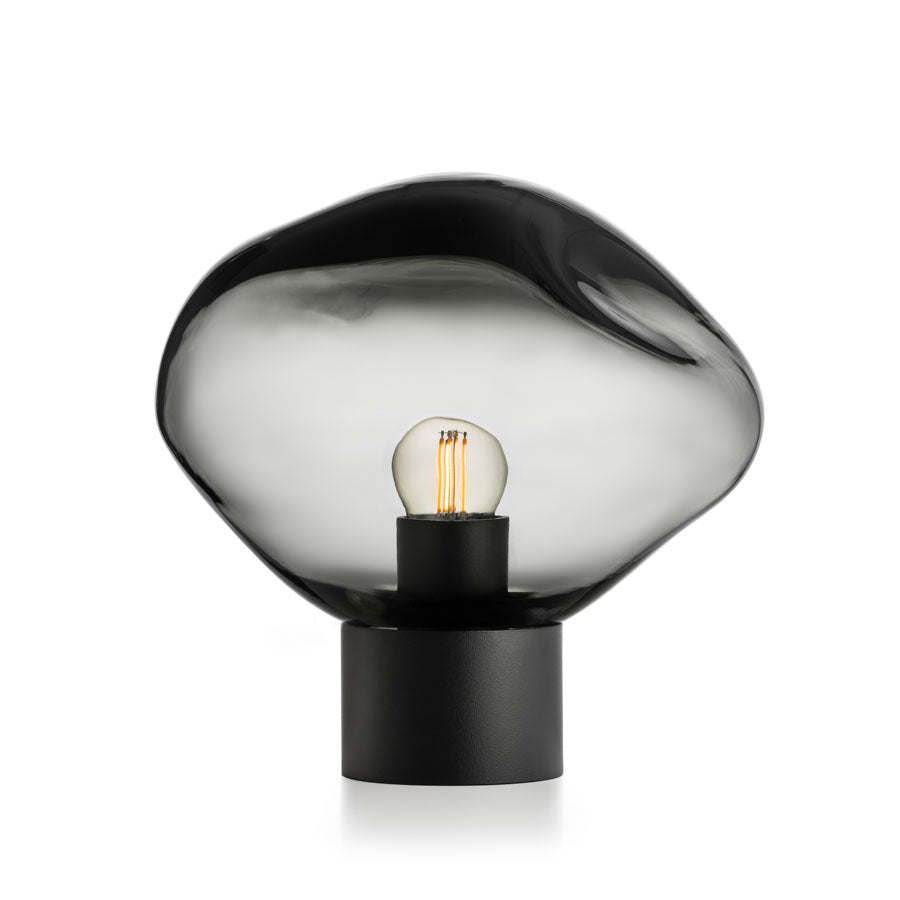 Stilig bordlampe fra Hadeland Glassverk, Crystal Stone i lys røkgrå, med en håndblåst glasskuppel som gir et elegant og dempet lys til ethvert rom.