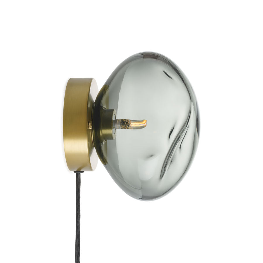 Hadeland Glassverk Crystal Stone vegglampe i røkgrå glass, sidevisning som viser detaljert håndverk og stilfullt veggoppheng med ledning.