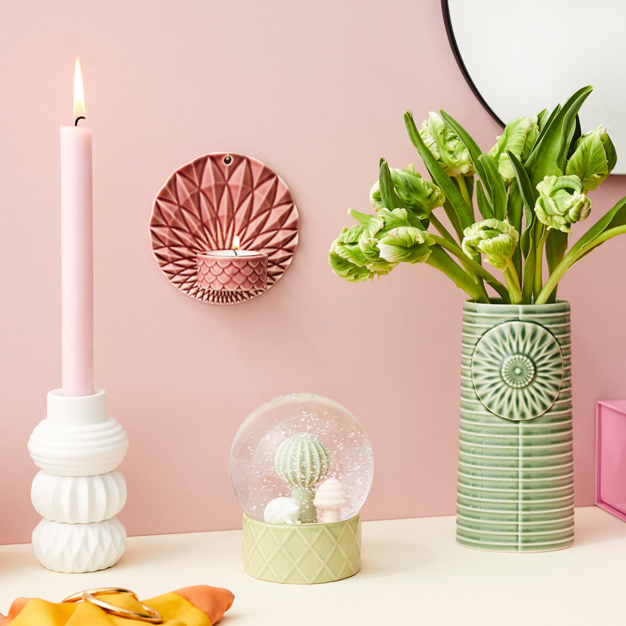 Sofistikert interiør med rosa telysholder, kombineres med en dekorativ vase og lysekrone, perfekt for stilige innendørsrom.