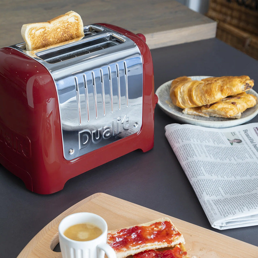 Dualit brødrister i bruk, rister perfekt toast med croissanter og en kopp kaffe i bakgrunnen.