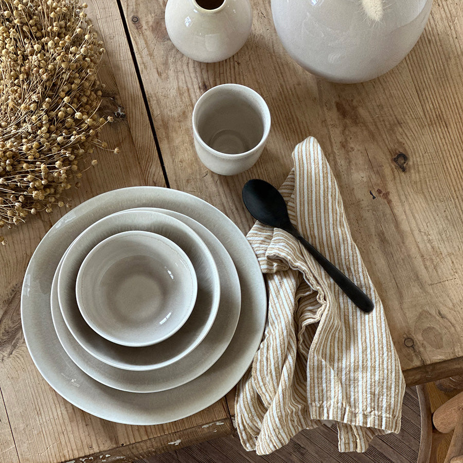 Ellie bolle i Latte som del av et dekket bord med servise, kopp og tekstilserviett