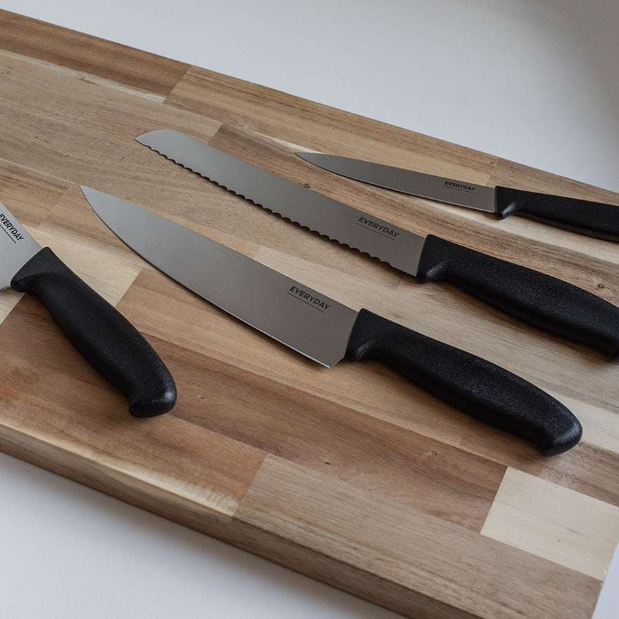 Everyday Cut kokkekniv 20 cm sammen med andre kniver fra serien på skjærefjøl i tre