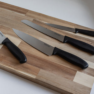 Everyday Cut kokkekniv 20 cm sammen med andre kniver fra serien på skjærefjøl i tre