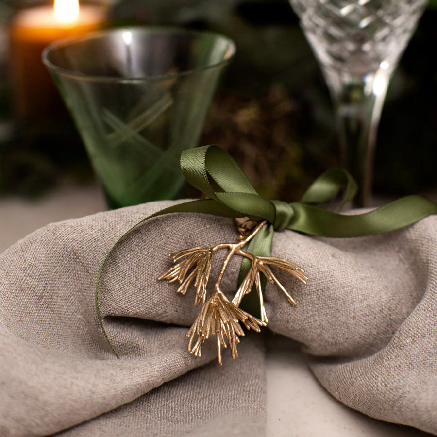 Flora Danica julepynt grangrein i gull dekorert på serviett med mørkegrønt bånd, elegant borddekorasjon til jul.