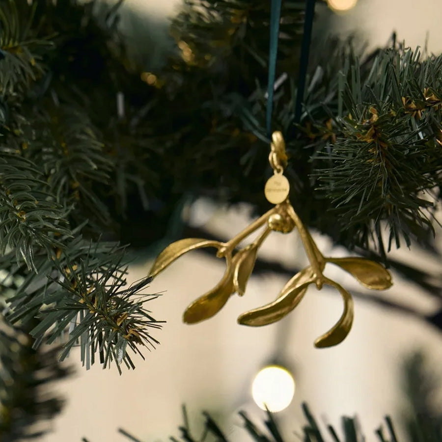 Misteltein ornament i 18 kt gull plassert på et juletre, fremhever den naturlige skjønnheten.