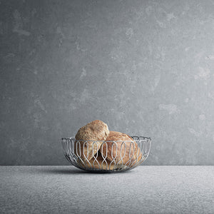 Georg Jensen Alfredo Brødkurv Liten 21cm brødkurv i blankt rustfritt stål med nybakt brød på bordet