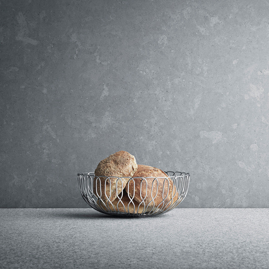 Georg Jensen Alfredo Brødkurv Liten 21cm brødkurv i blankt rustfritt stål med nybakt brød på bordet