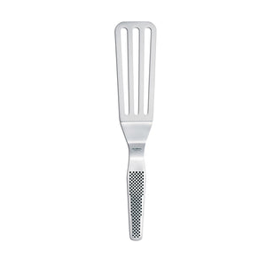 Global stekespade GS-26 på 15 cm, laget av slitesterkt rustfritt stål, med perforert design for sunn matlaging og ergonomisk skaft for godt grep.