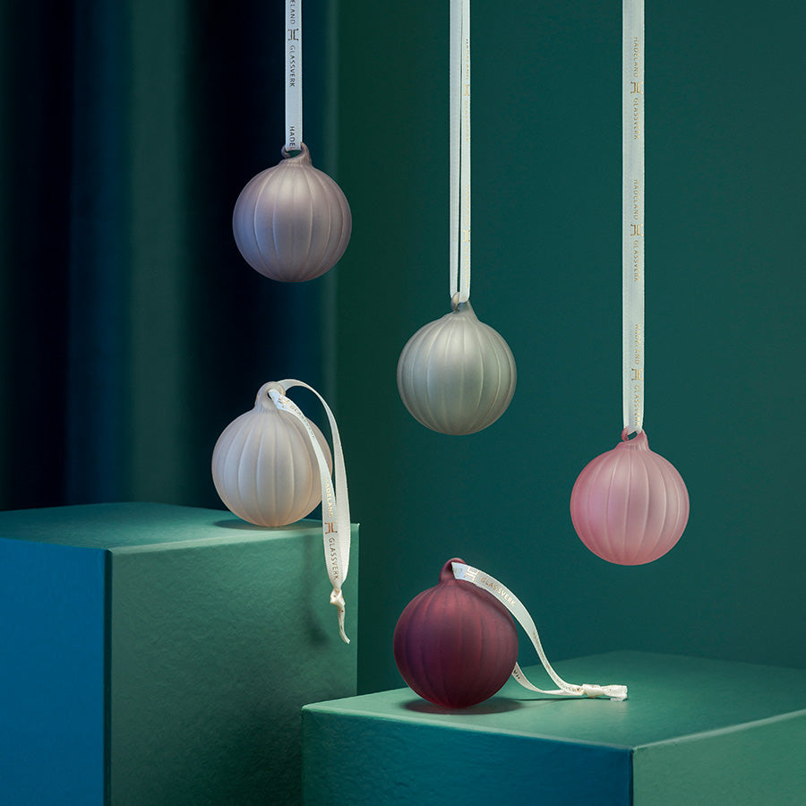 Elegante frostede glasskuler fra Hadeland Glassverk som henger vakkert i soft fargetoner. Settet inneholder fem julekulene i dempede farger, ideelle for moderne dekorasjoner.