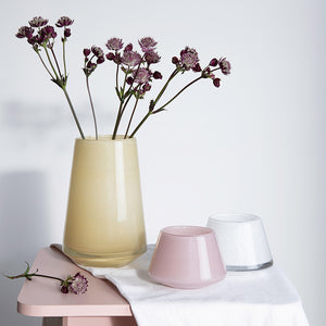 Tre Hadeland Glassverk lyslykter i forskjellige farger, inkludert hvit, rosa og gul, som viser allsidige dekorasjonsmuligheter.