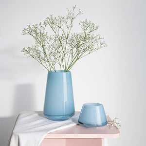 Lyslykt plassert med blomster i en lys blå vase, viser hvordan lyslykten kan brukes som dekorativ detalj i hjemmet.