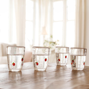 Fire Hadeland Jordbær glass på et bord med klar drikke, passer perfekt til sommermøter og hyggetreff.