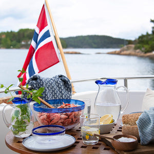 Hadeland Glassverk Skjærgård mugge på en båt med Norsk flagg, servert med sjømat og forfriskninger.