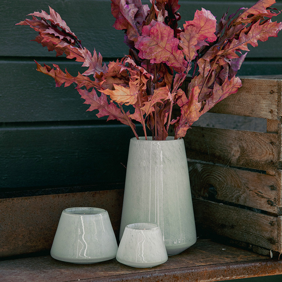 To off-white Dugg telysholdere med telys og vase med tørkede blader
