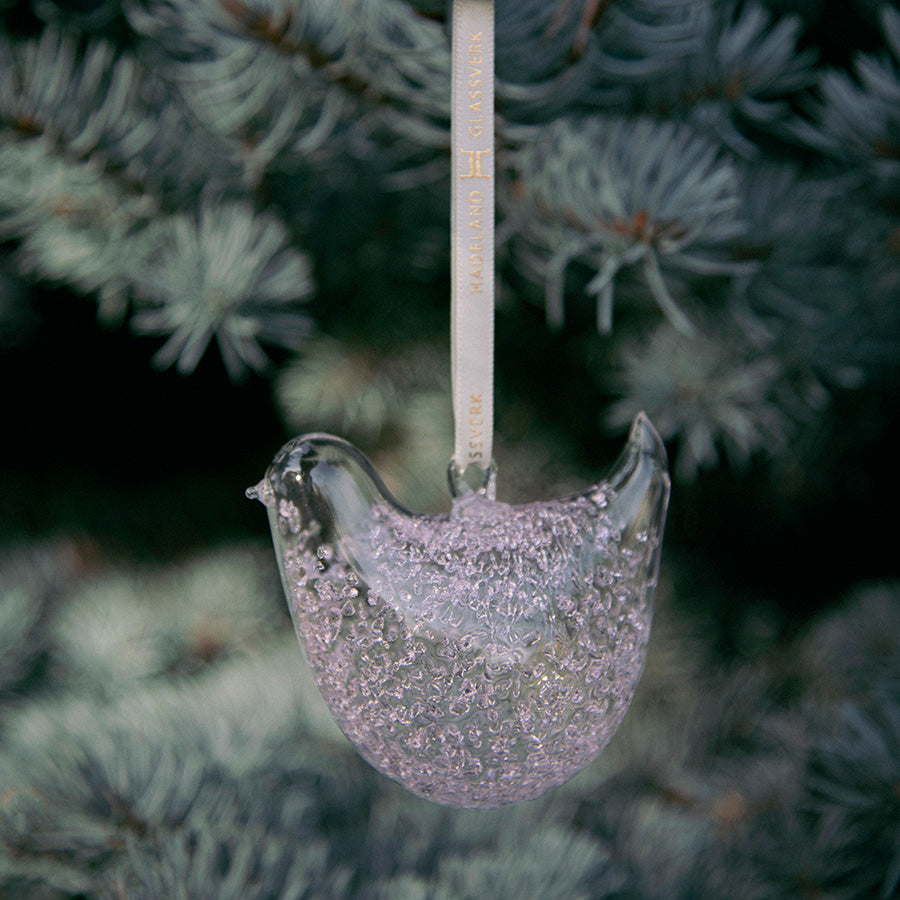 Rosa spettet glass turteldue fra HG Jul-kolleksjonen henger på en grankvist