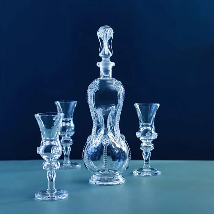 Nøstetangen karaffel i klart krystallglass med dekorative likørglass mot blå bakgrunn