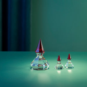 Diamantnisse i klart glass med rød lue vist sammen med nisser i ulike størrelser