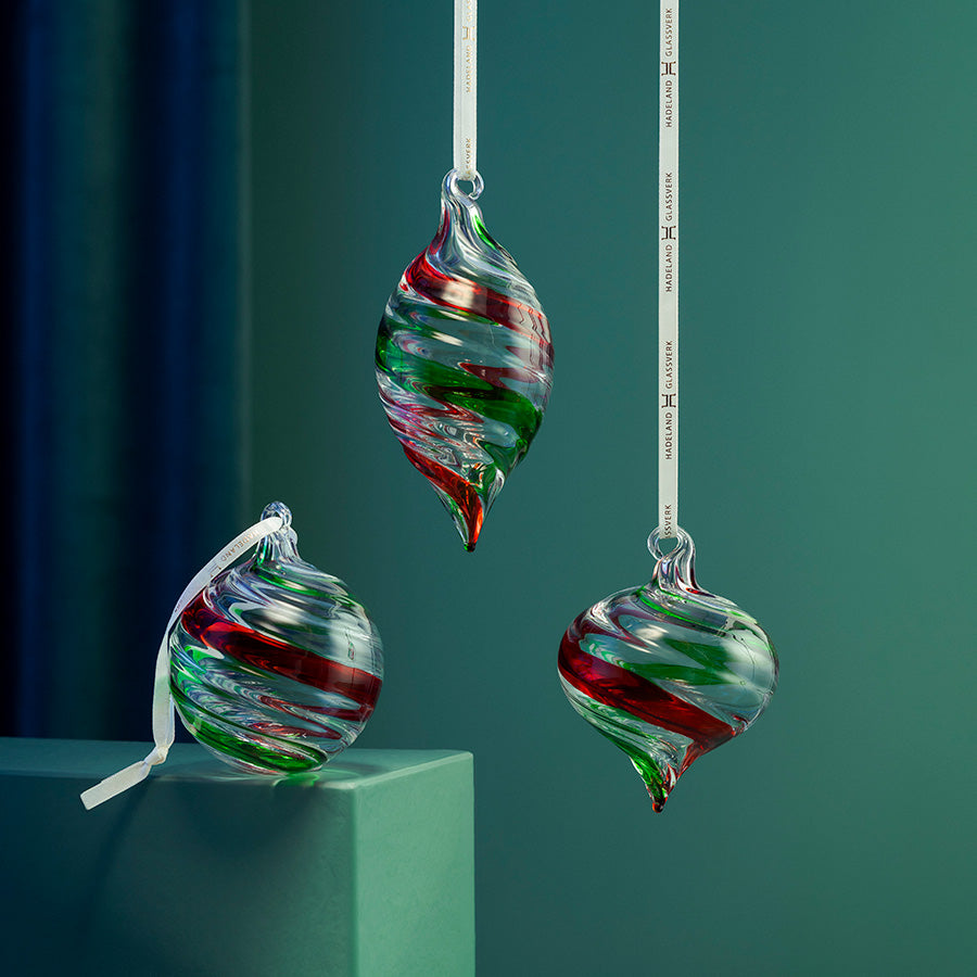 Røde og grønne glasskuler i tre ulike former, vist hengende og stående som julepynt