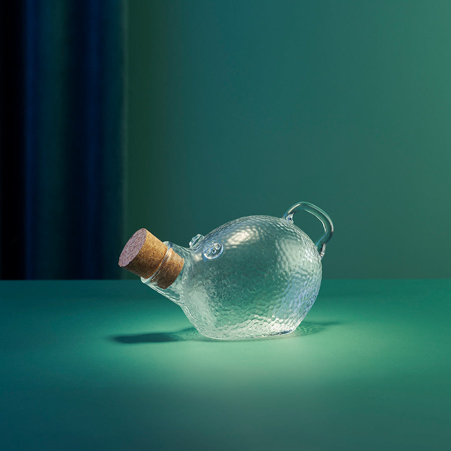 Dekorativ Godtegris krukke i klart glass med korkpropp, vist i stemningsfull belysning