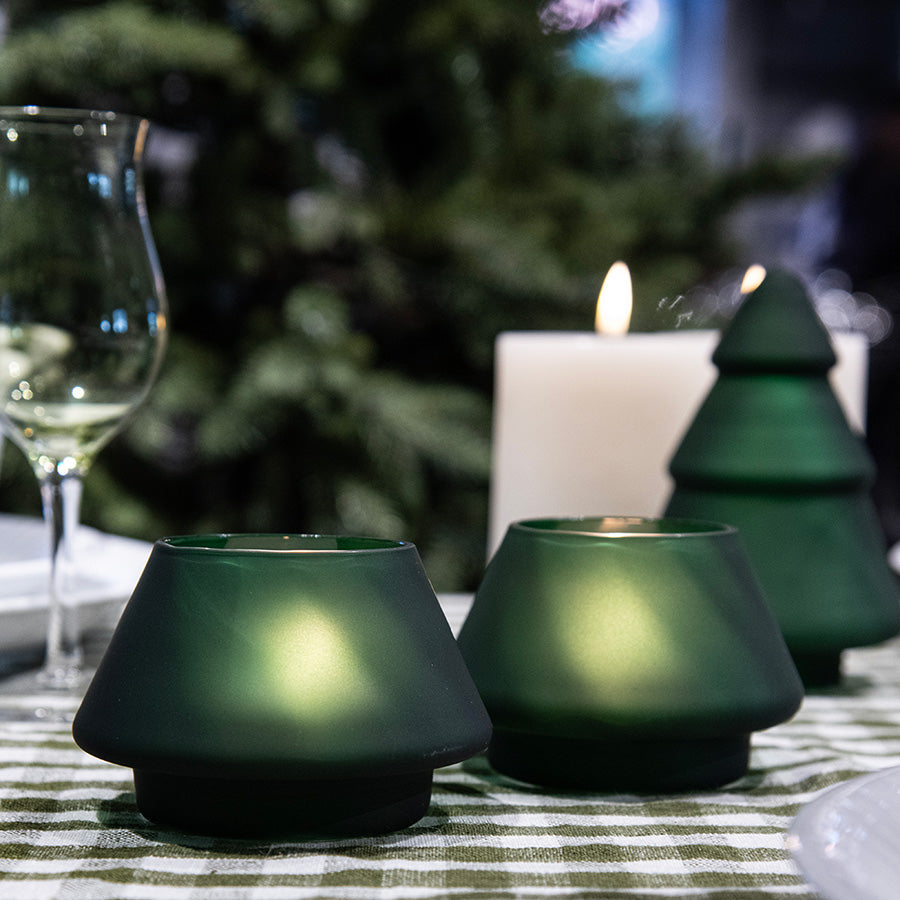 Hadeland Glassverk frostet grønne lyslykter på et bord, med julepynt og feststemning, skaper en koselig atmosfære til middagsselskap.