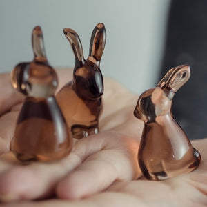 Tre små glassharer som holdes i en hånd, som viser detaljer av designet.