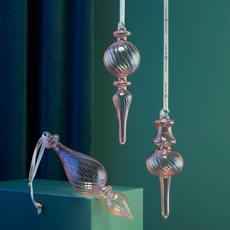 Ornament i rosa optikkglass fra Hadeland Glassverk, vist som elegant julepynt i ulike former og farger