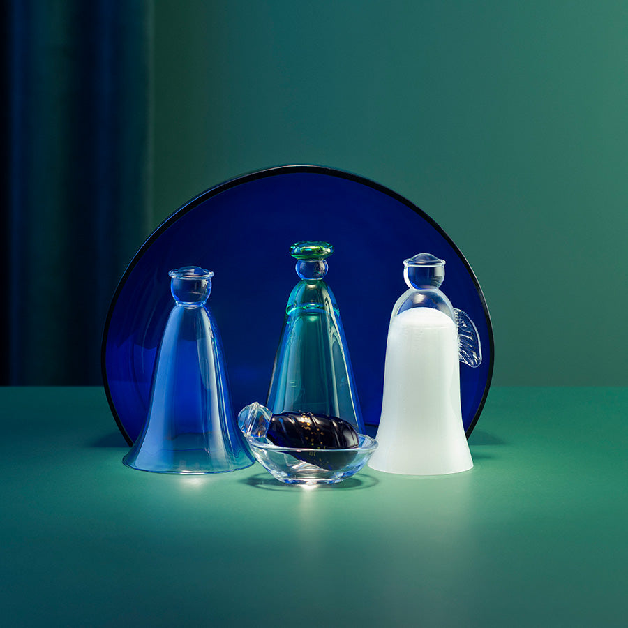 Julekrybbe i glass med seks deler og blå himmelhvelving, dekorativt presentert i stemningsfull belysning