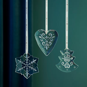Dekorative ornament i klart glass med inngravert mønster, vist som hjerte, juletre og snøfnugg