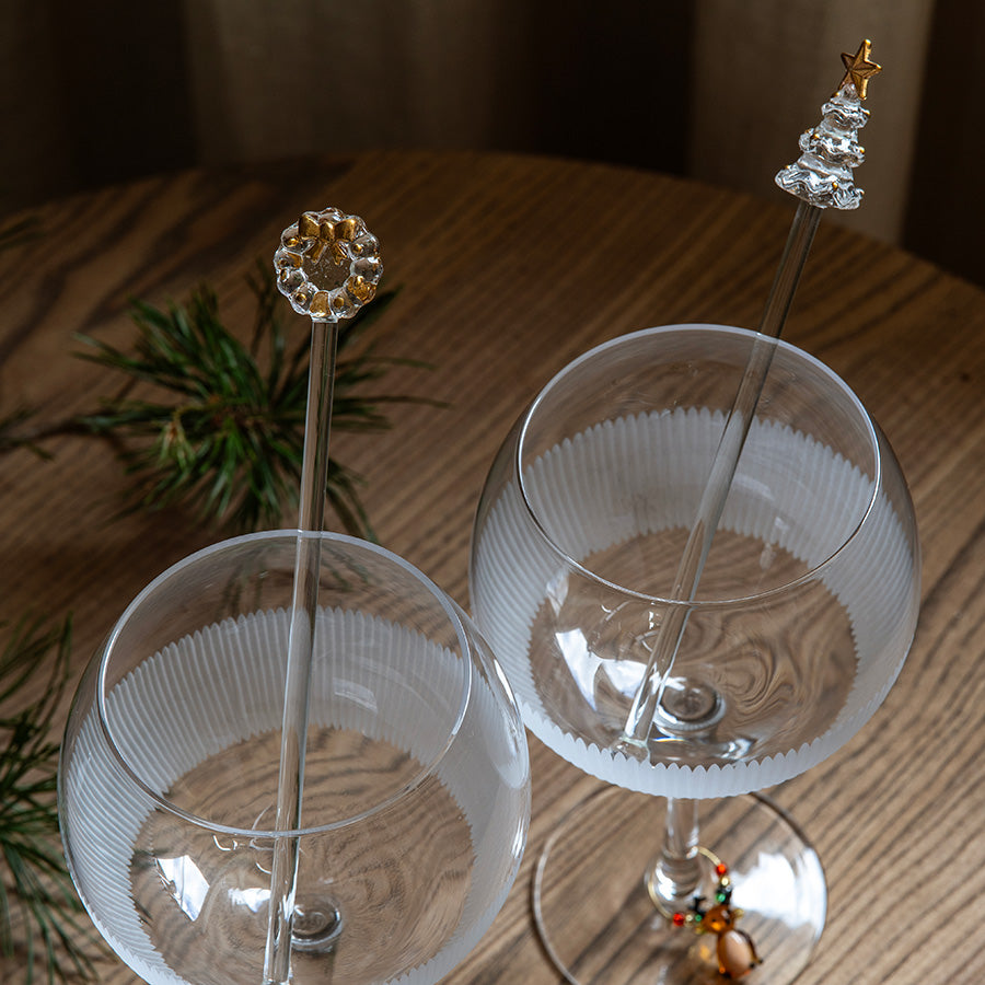 Rørepinner med gulldekor i glass med julemotiv, brukt i festlige vinglass