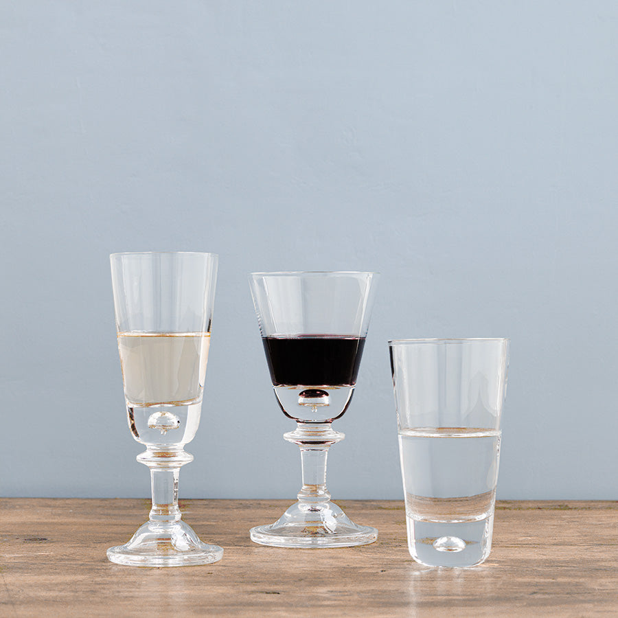 Hadeland Glassverk Tangen glass i klart krystall fylt med rødvin, sammen med andre drikkeglass