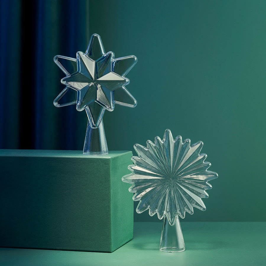 Klar toppstjerne i glass fra Hadeland Glassverk sammen med dekorativt glassornament i elegant juledekorasjon