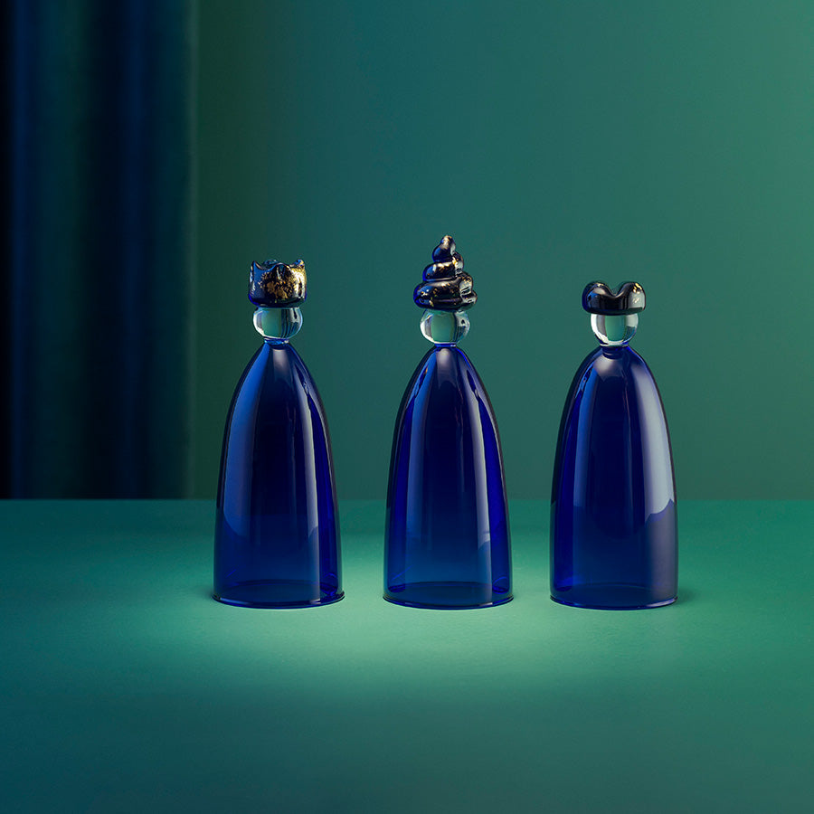 Tre vise menn i mørkt koboltblått glass fra Hadeland Glassverk, dekorativt presentert i stemningsfull belysning