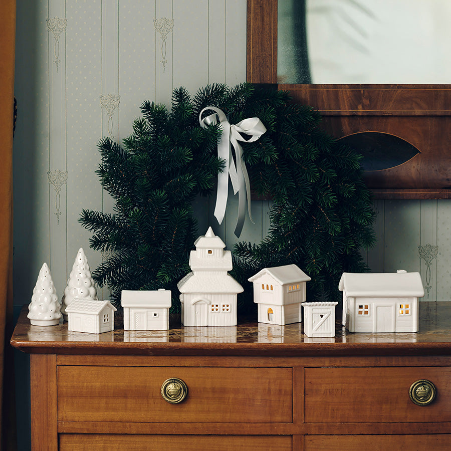 Porsgrunds Porselænsfabrik Jul På Tunet samling av hvite porselen hus inkludert stavkirken, dekorert med juletre og krans, skaper en koselig vinterlig atmosfære.