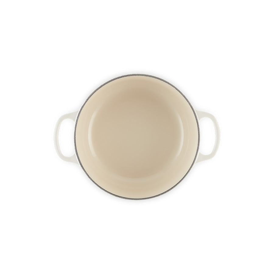 Bunnvisning av Le Creuset støpejernsgryte i meringue, viser det tidløse designet og den glatte emaljerte overflaten.