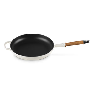 Le Creuset støpejernspanne på skrå, med 28 cm diameter og trehåndtak.